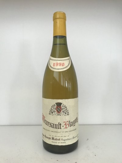 Lot 22:  Domaine Joseph Matrot Meursault-Blagny 1990 (2 bottles) Provenance: Recently removed from a damp French country house cellar. Levels: 1x1.5cm, 1x2cm, damp soiled labels. Excellent colour.