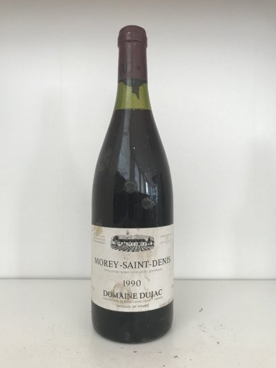 Lot 48:  Domaine Dujac Morey St Denis 1990 (1 bottle) Provenance: Recently removed from a damp French country house cellar. Level: 2.5cm, damp soiled label.