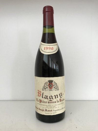 Lot 49:  Domaine Joseph Matrot  Blagny 1er Cru La Piece sous le Bois Rouge 1990 (7 bottles) Provenance: Recently removed from a damp French country house cellar. Levels: 6x1cm, 1x1.5cm, repacked from damaged original carton.